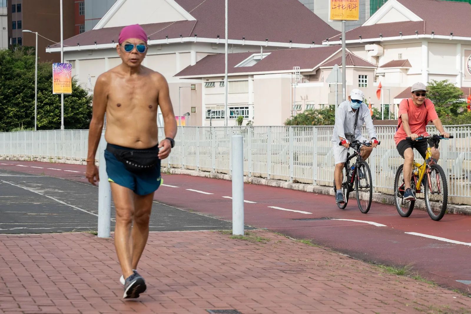 Shirtless man sweating heavily while running along a path in hot, humid weather