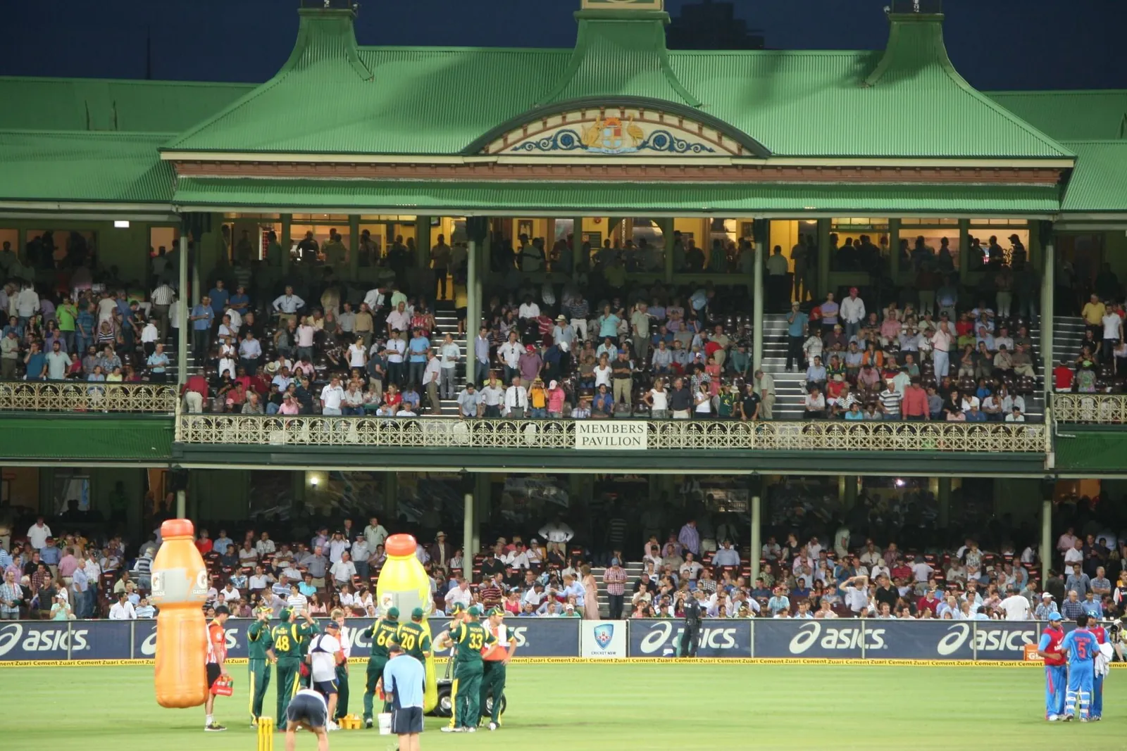 Players gathered on the field during a drinks break at an India versus Australia cricket match