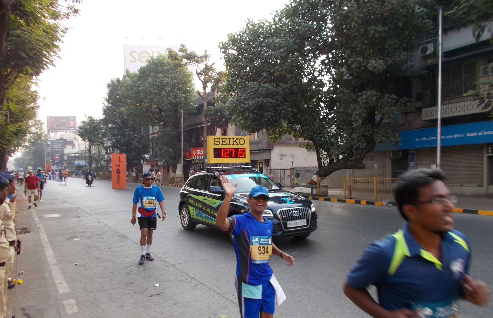 Runners passing the 25 kilometre mark of the Mumbai Marathon on a city road